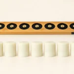 A 7-pack of non-toxic silicone light cores lined up in front of a plain bamboo charging dock with magnetic brass contacts and a Type-C port.