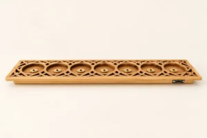 rechargeable-flameless-candle-bamboo-type-c-carved-dock-1 A 7-slot carved bamboo charging dock with geometric patterns, magnetic brass contacts, and Type-C port for flameless candle cores.