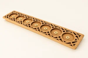 Perspective view of a 7-slot carved bamboo charging dock showing intricate geometric patterns and magnetic brass contacts for flameless candles.